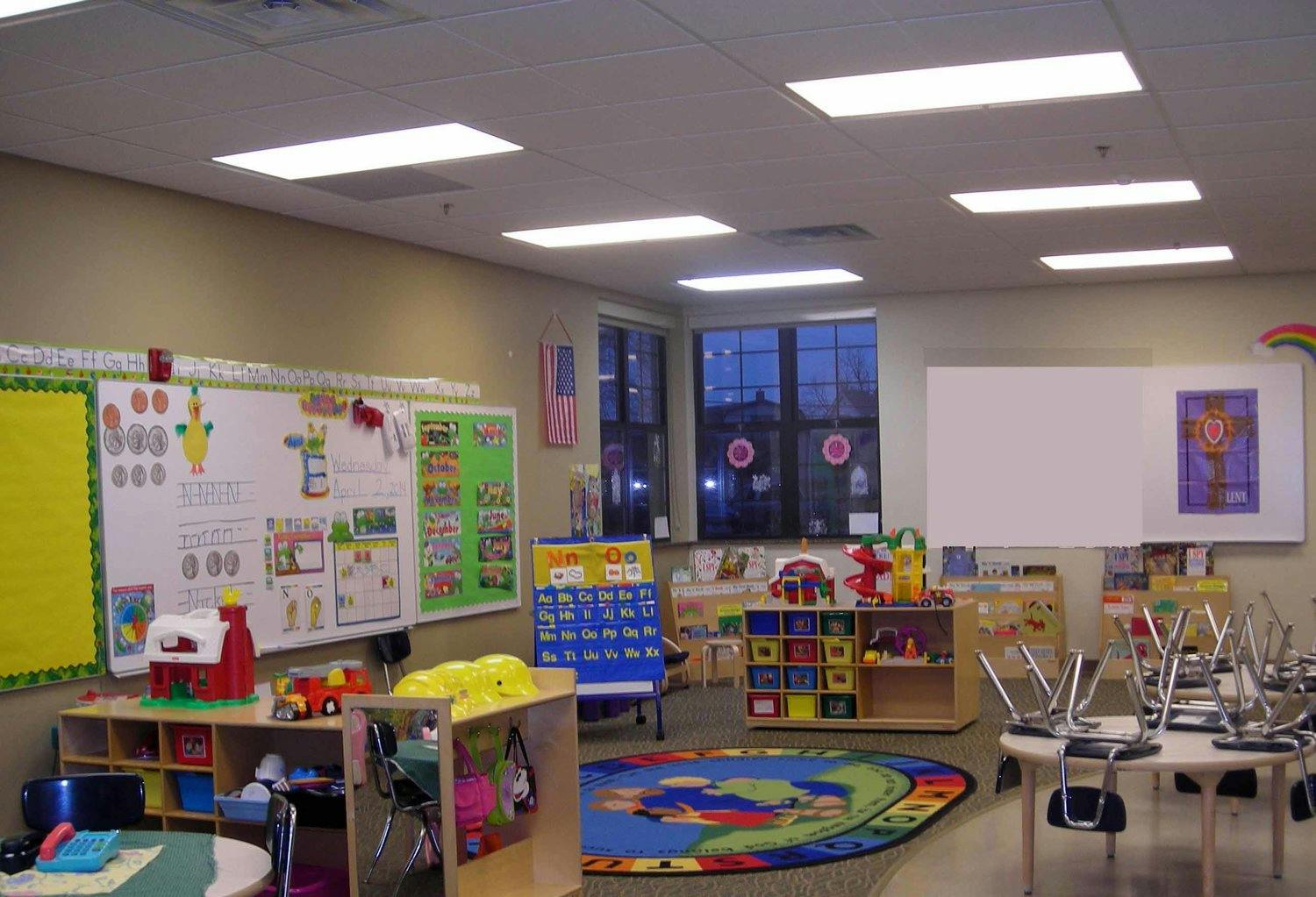 Empty classroom with tables, chairs, and learning materials