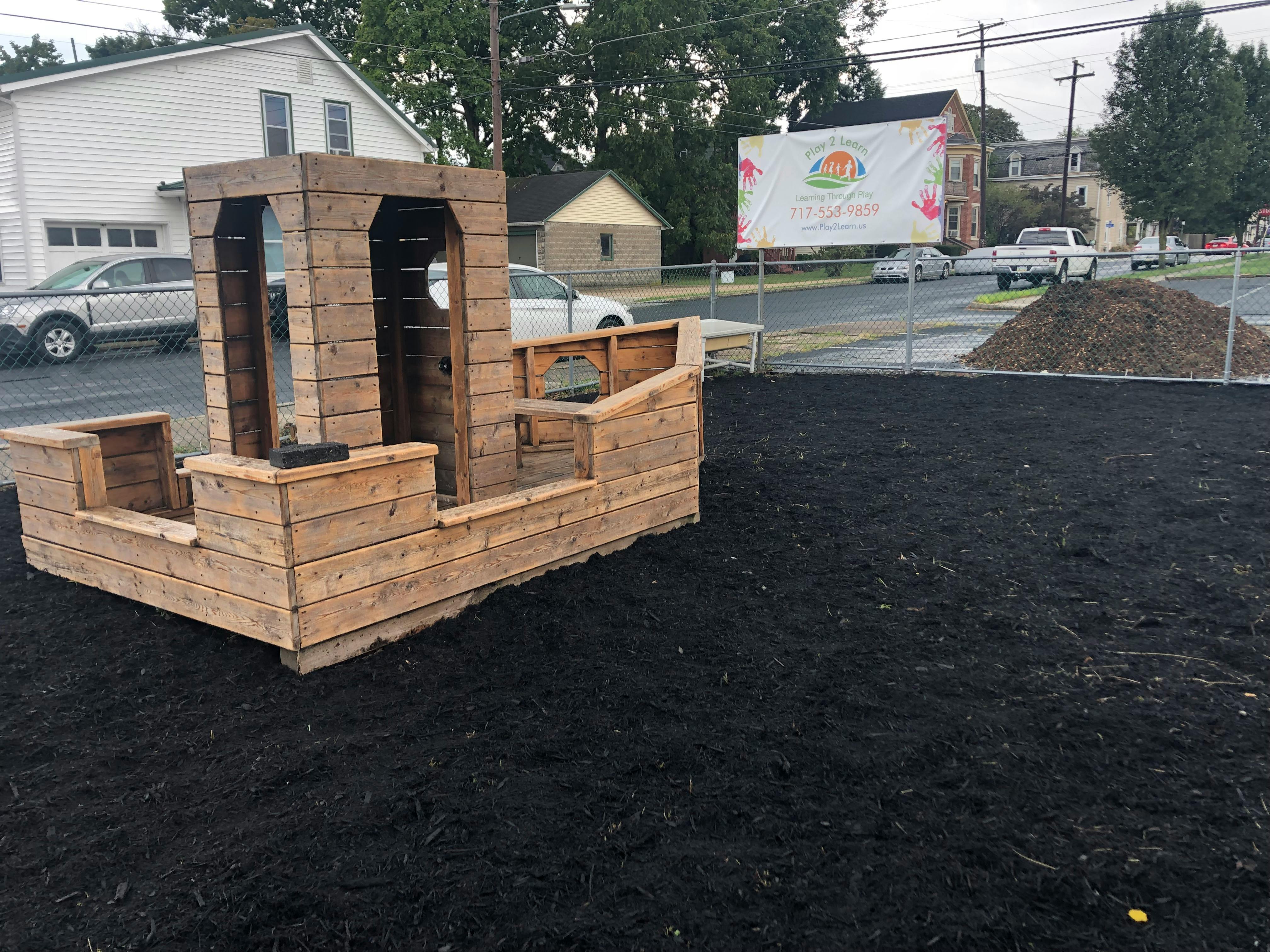 Wooden boat-shaped playground structure on dark ground