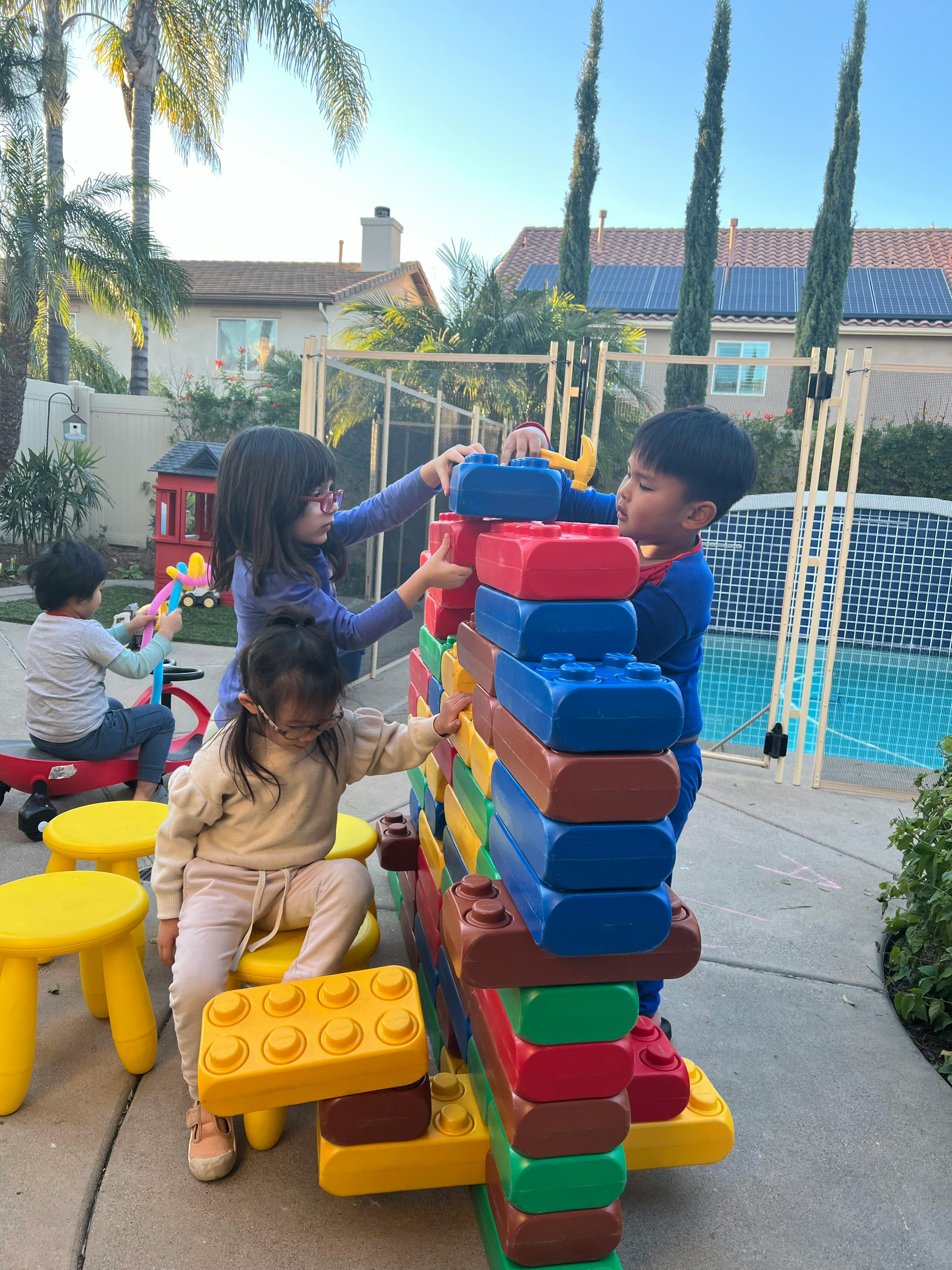 Children playing with large colorful building blocks outdoors