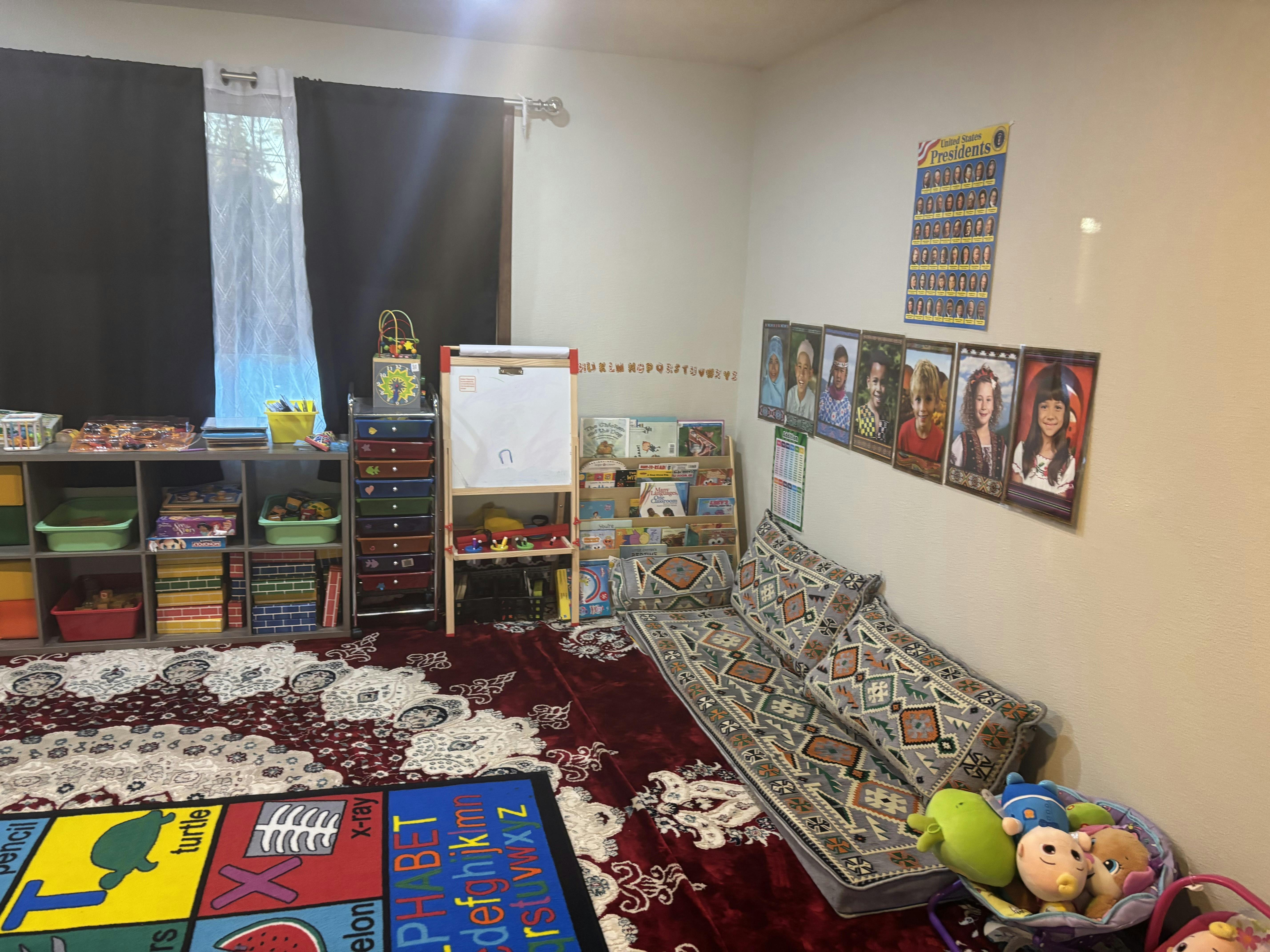 Playroom with shelves of books and toys, a whiteboard, and floor seating
