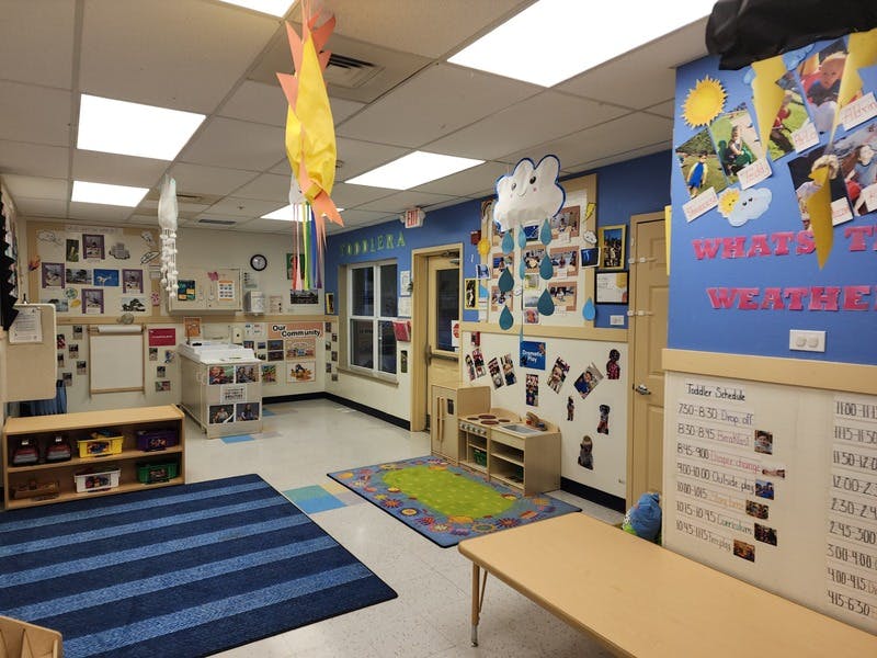 A classroom with blue walls, colorful decorations, children's artwork, and furniture