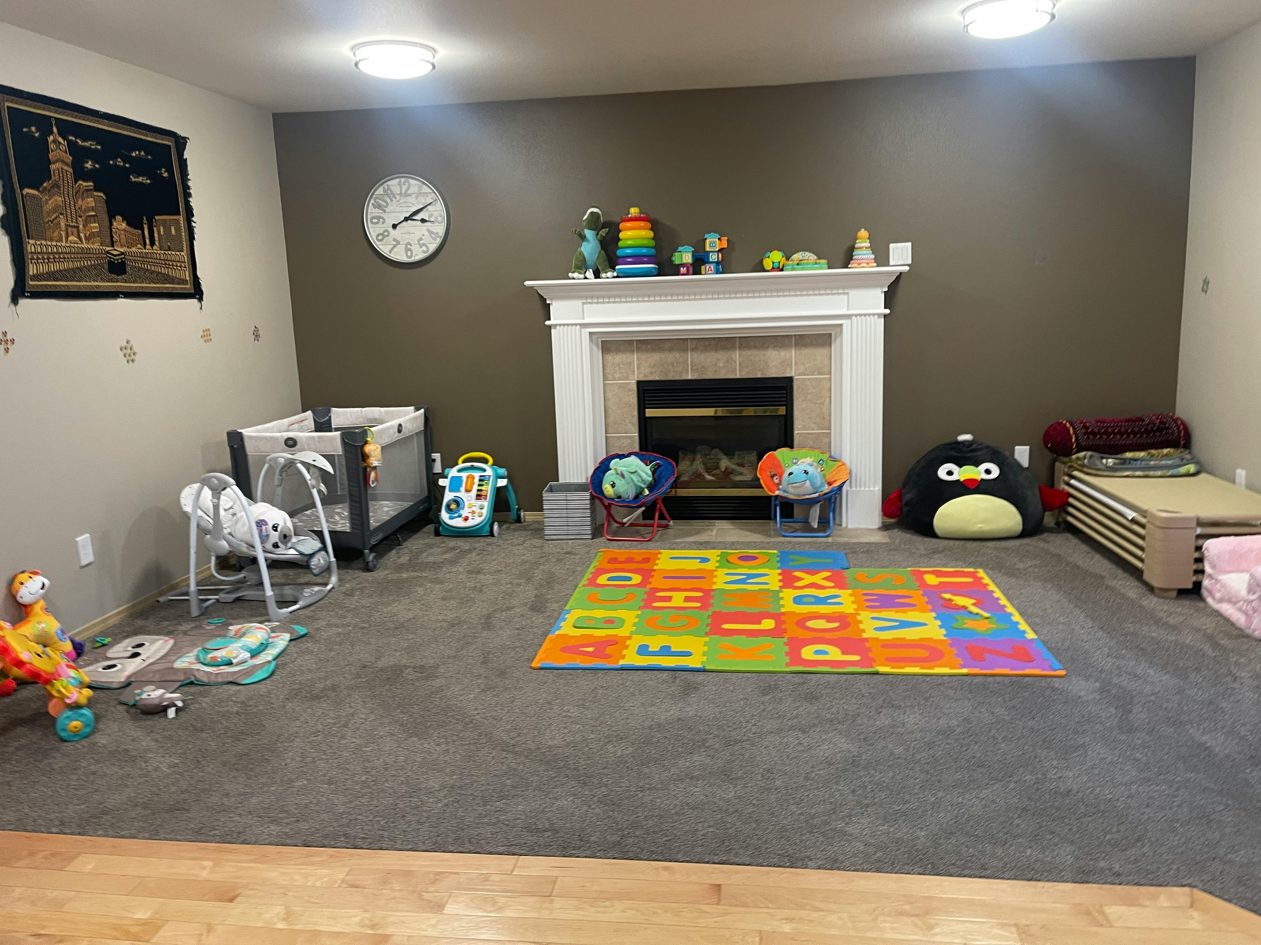 Playroom with crib, baby swing, and colorful alphabet mat