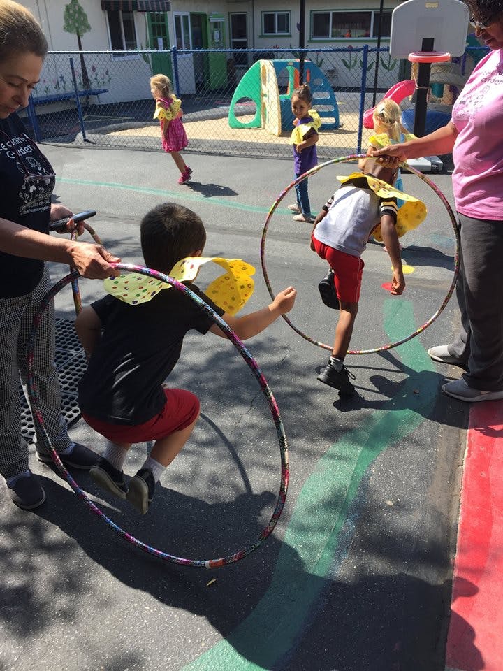 Adults and children playing with hula hoops outdoors
