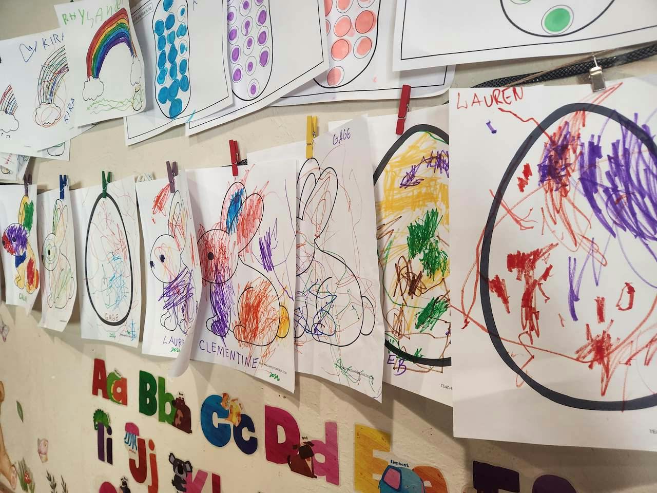 Child artwork of eggs and bunnies displayed on a classroom wall