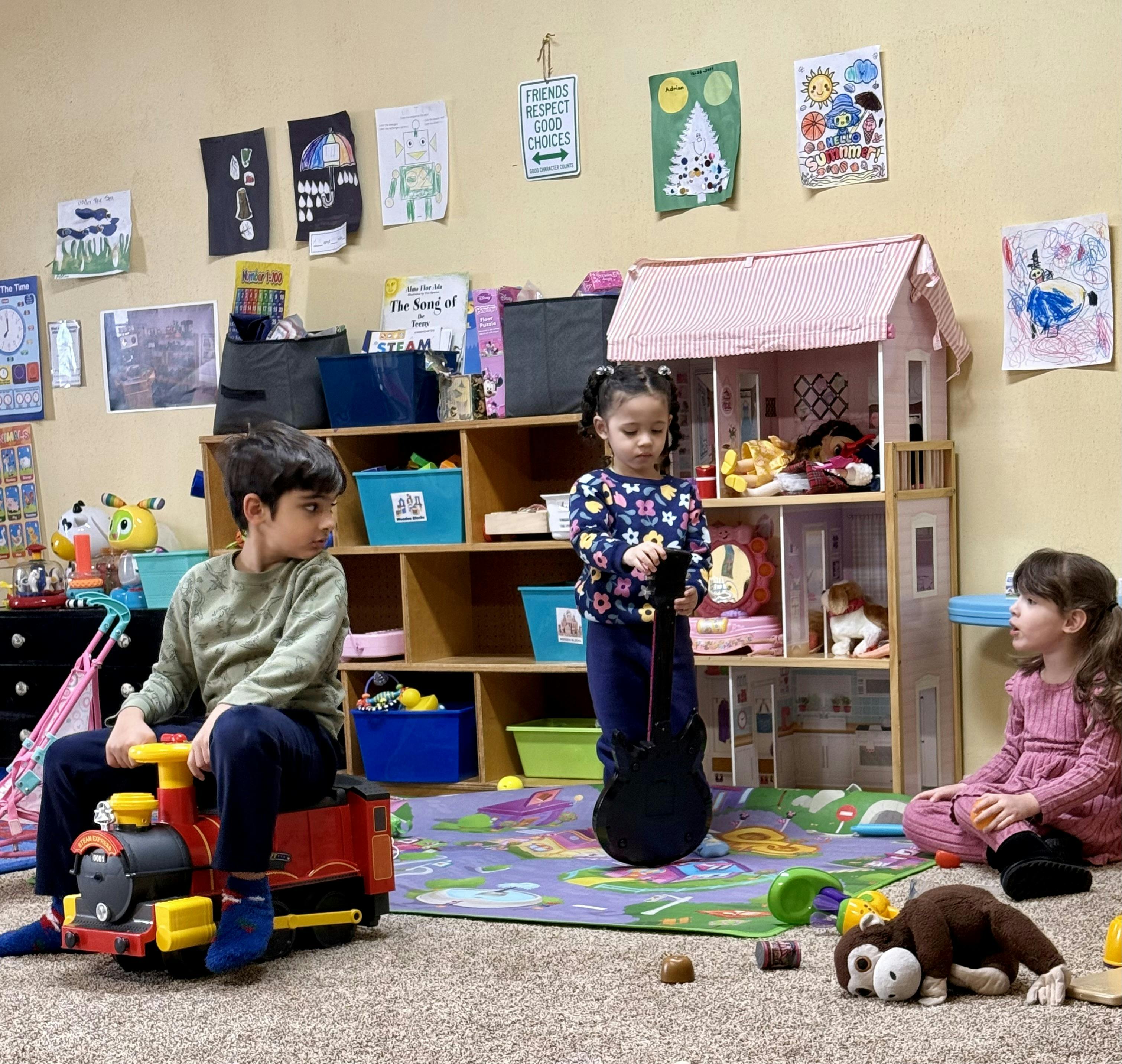 Three children playing in a room with toys and child artwork