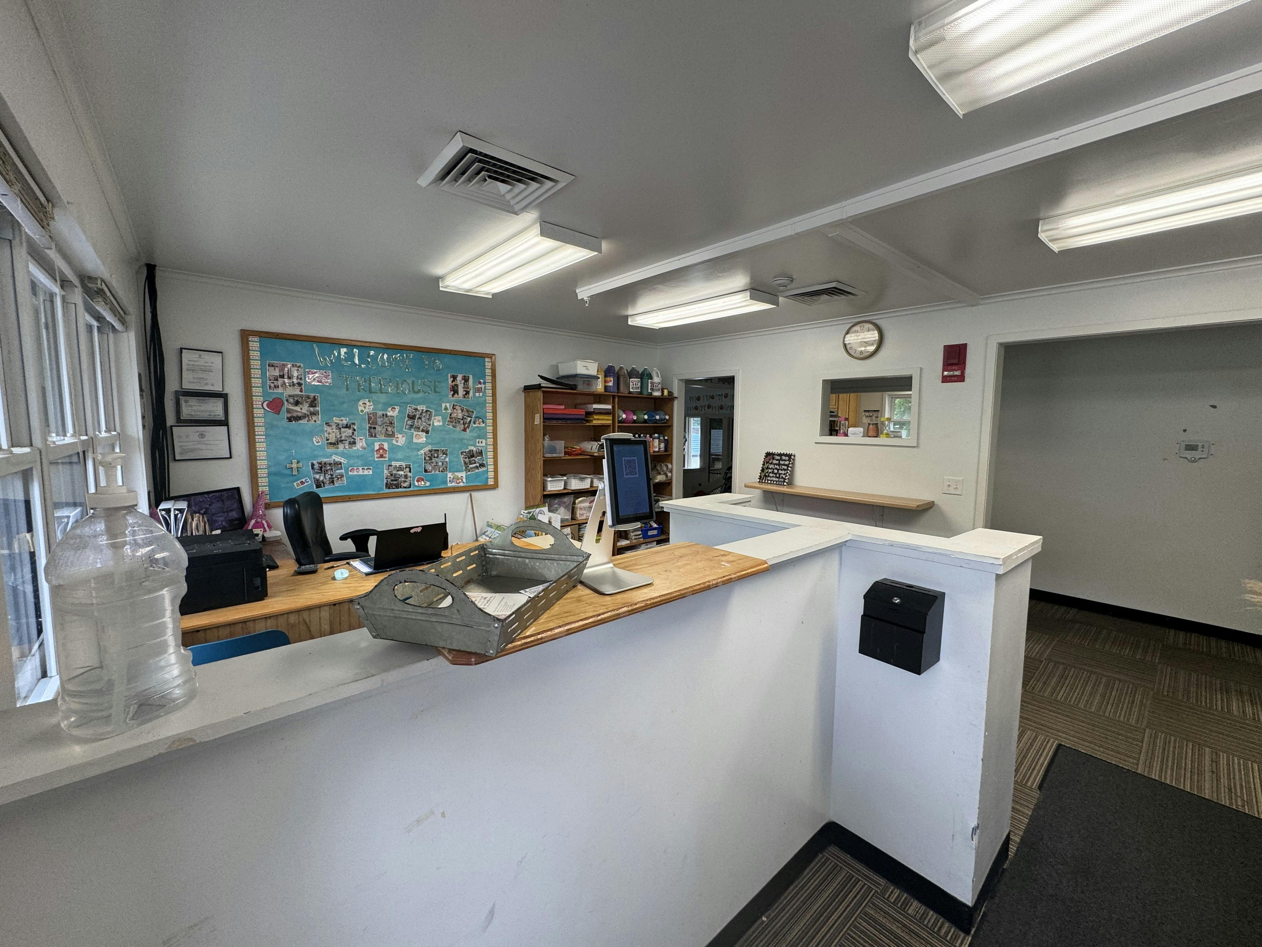 Reception desk in an office with a bulletin board and shelves