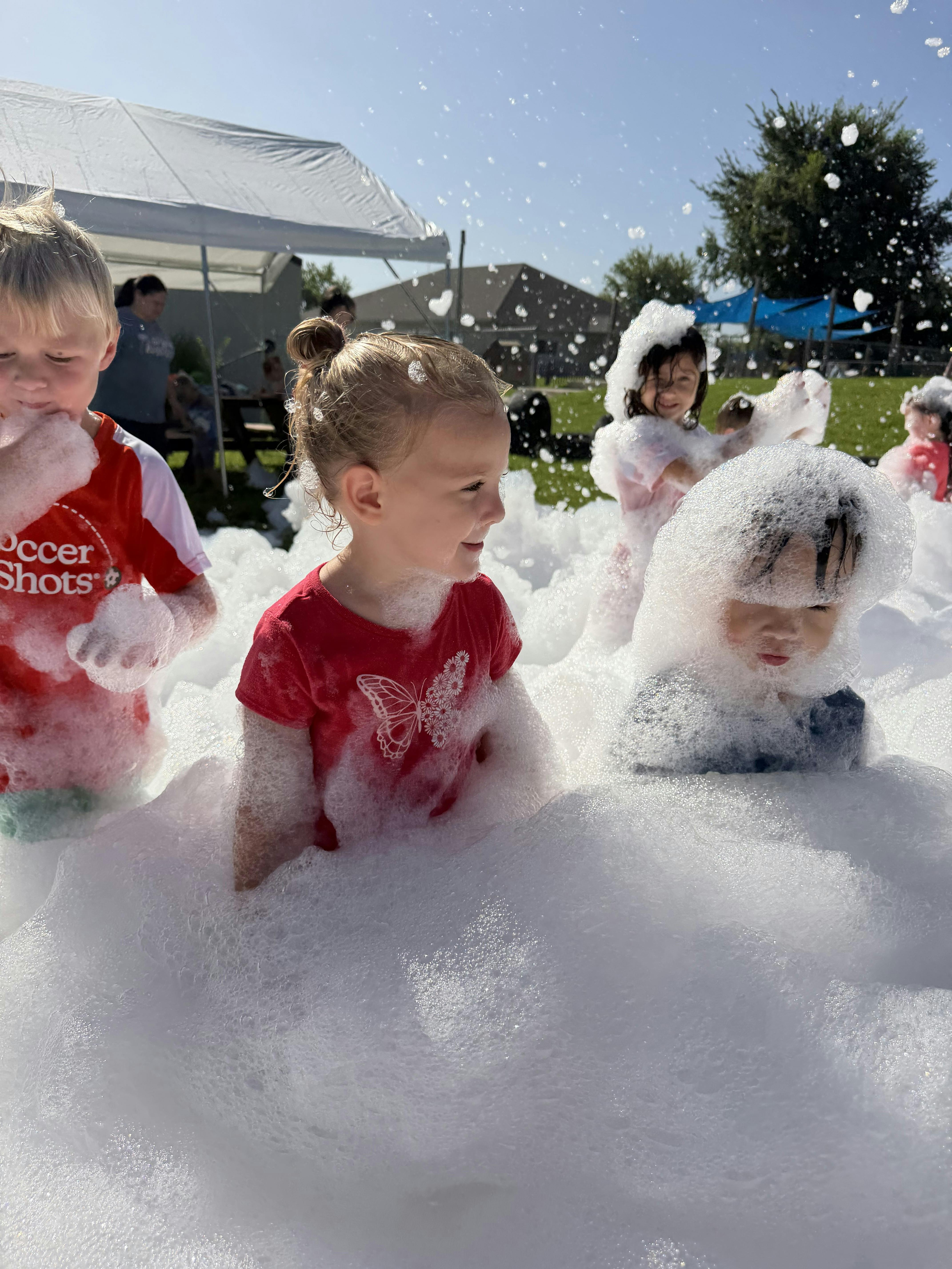 Children playing in a large pile of outdoor soap foam