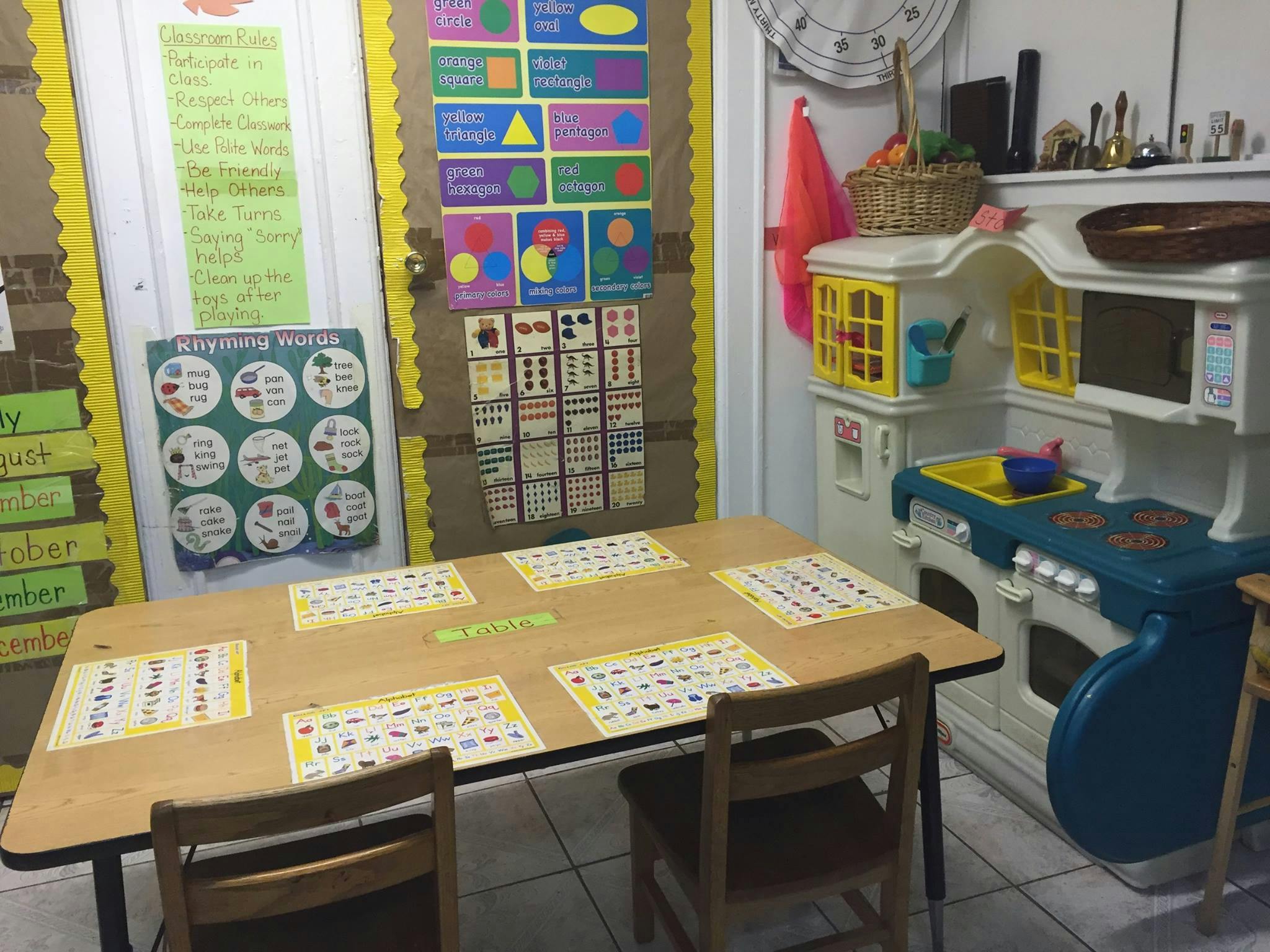 Classroom with a table set for children and a play kitchen
