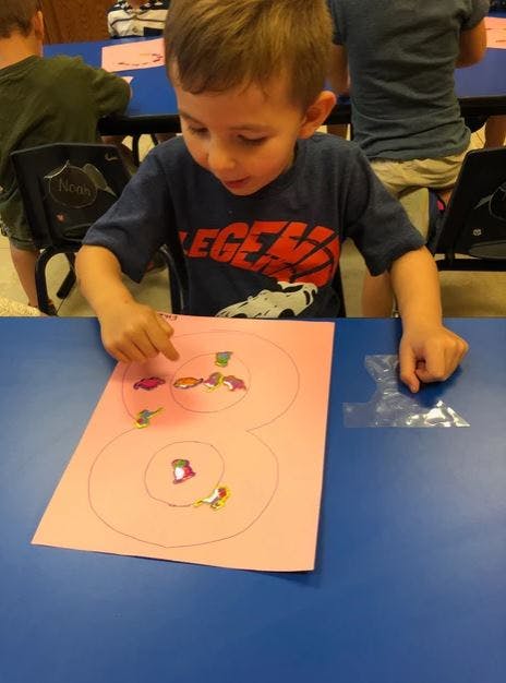Child working on a craft project at a table