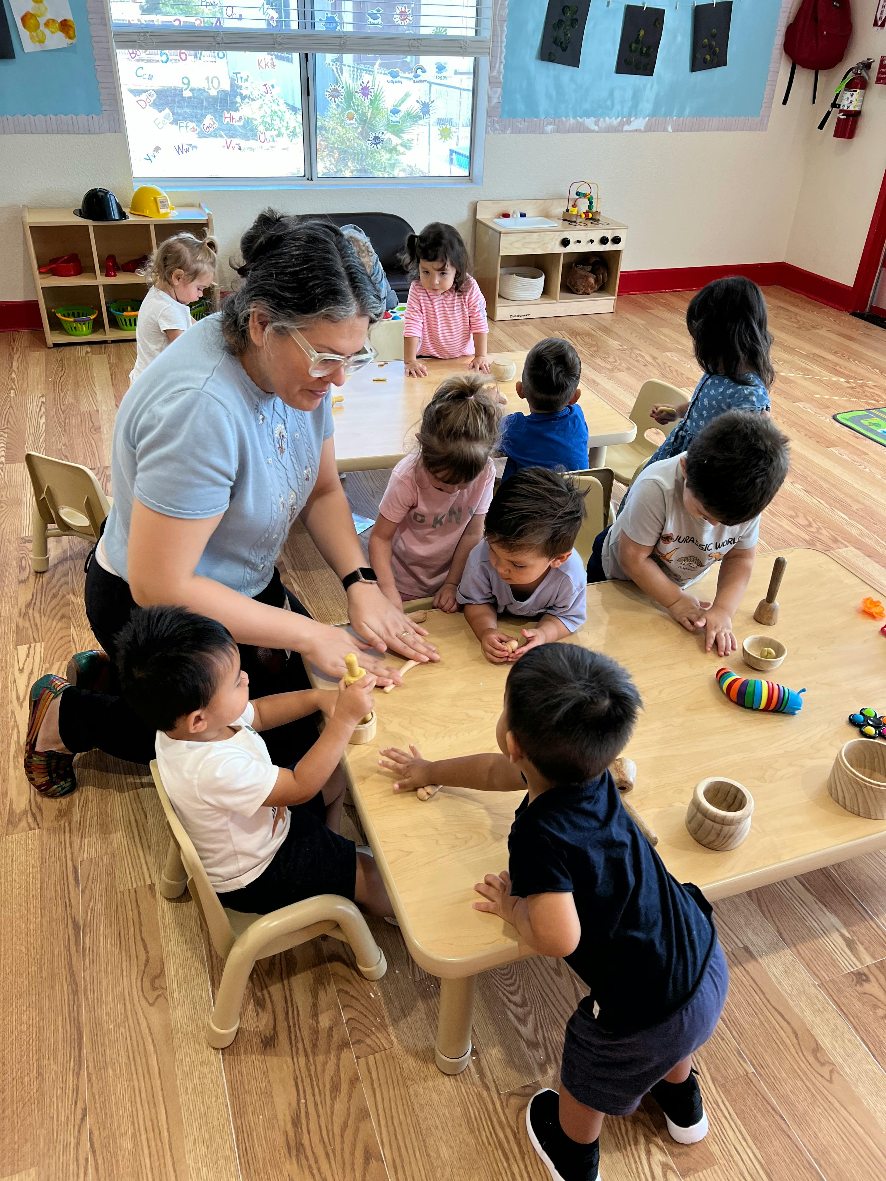 Adult and children gathered around a table in a classroom