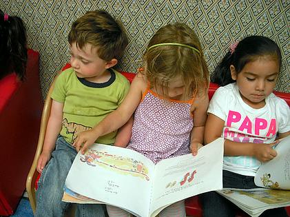 Three children sitting and reading books