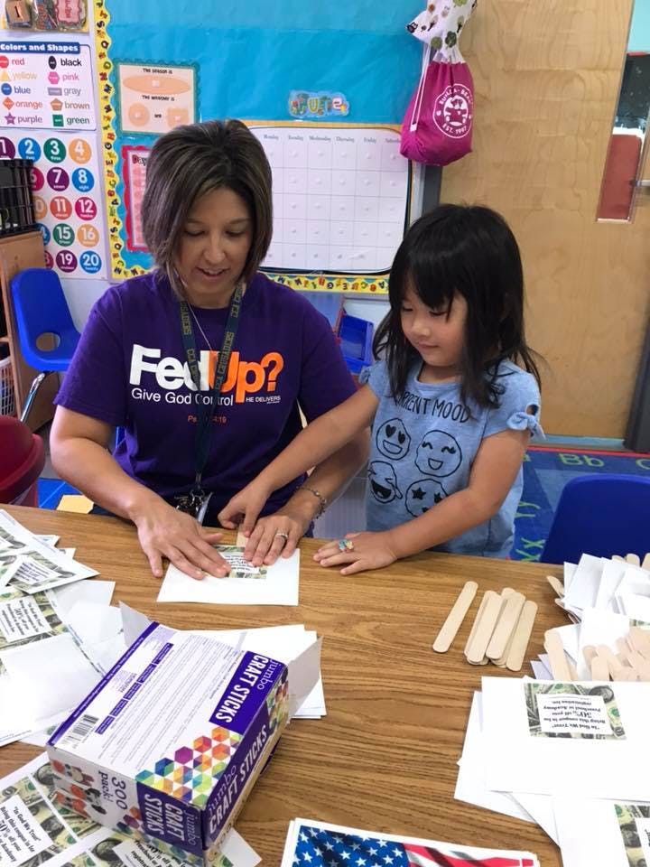 Person and child doing a craft project at a table