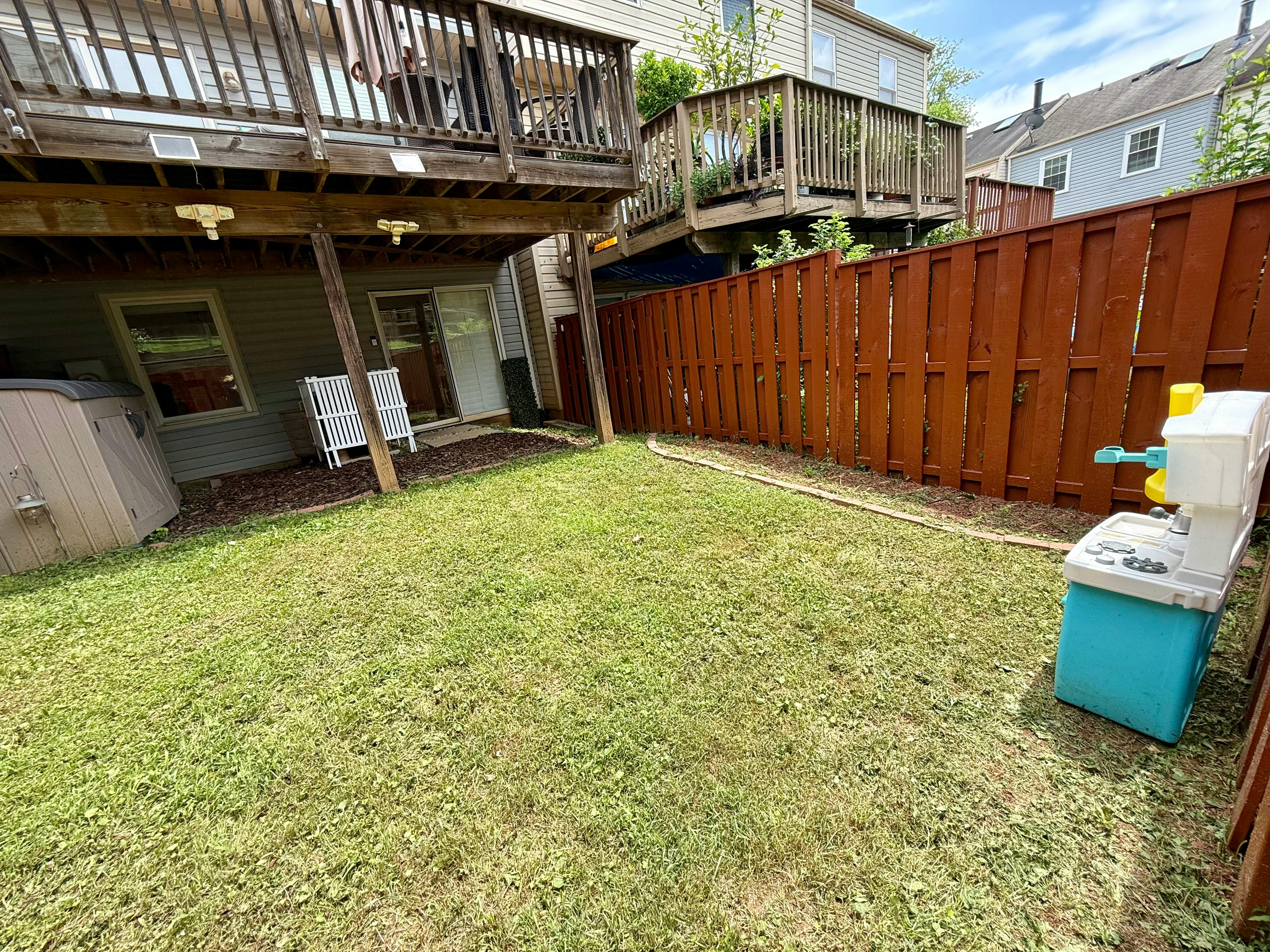 Small backyard with wooden decks and a brown privacy fence