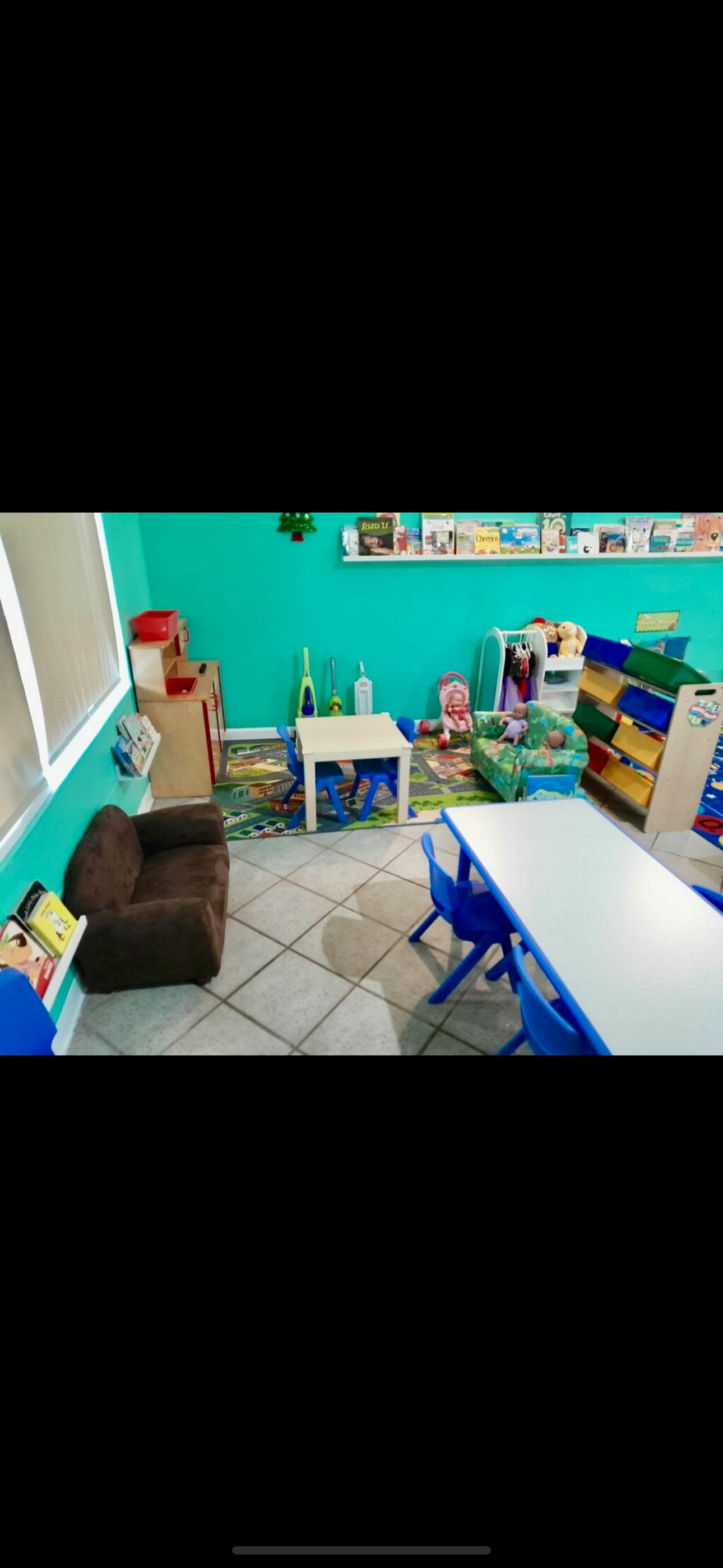 Children's play area with small tables and chairs, toys, and books
