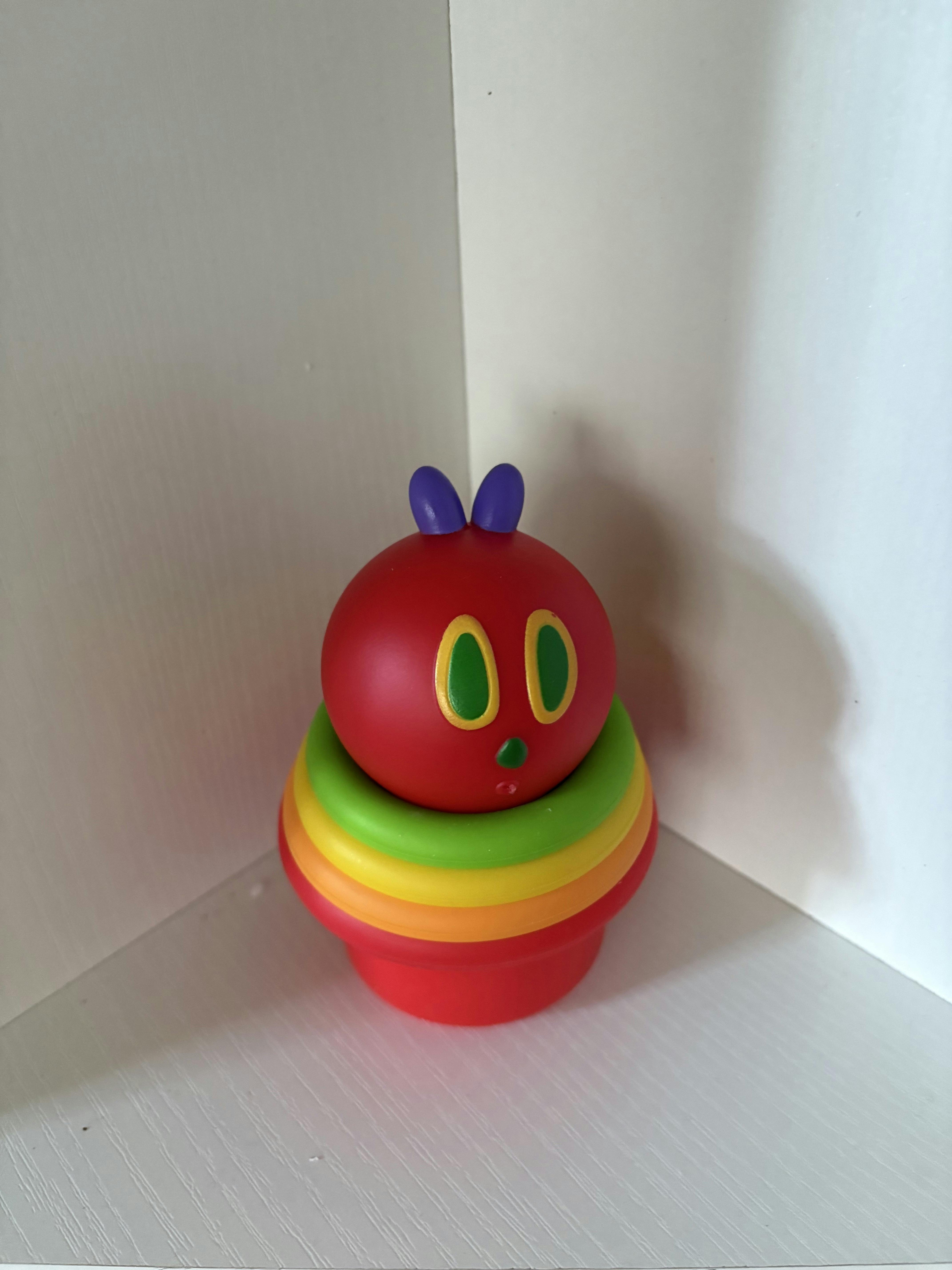 Red caterpillar toy with stacked rainbow-colored body rings