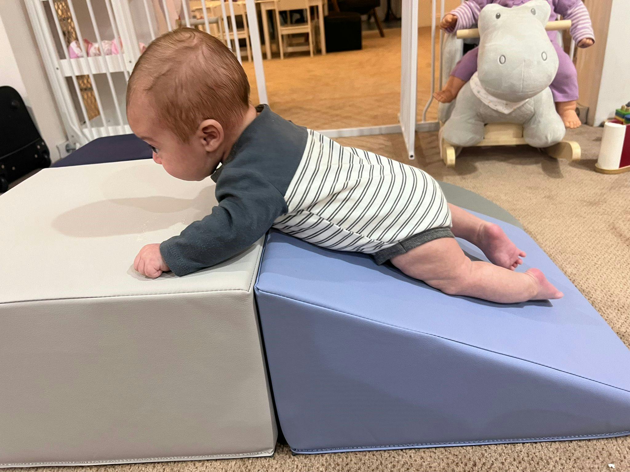 Child on stomach on a blue and white play mat