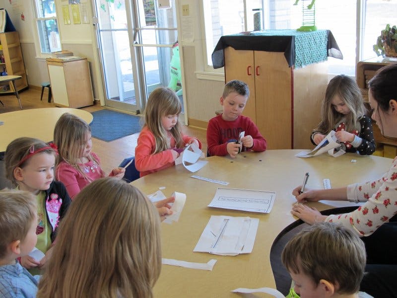 Children and an adult at a table doing crafts