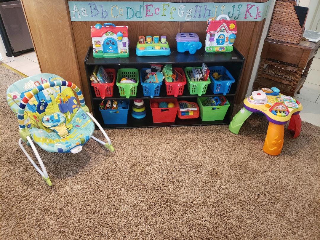 Baby bouncer, toy shelf with bins, and activity table