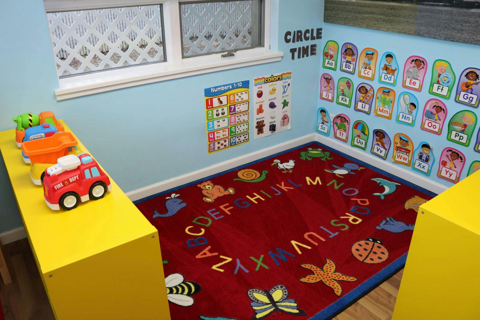 Classroom corner with alphabet rug, toys, and wall decorations