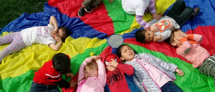 Children lying on a colorful parachute