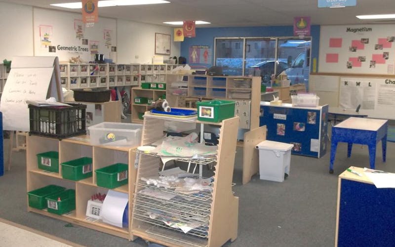 Classroom filled with shelves, storage bins, drying racks, and signs
