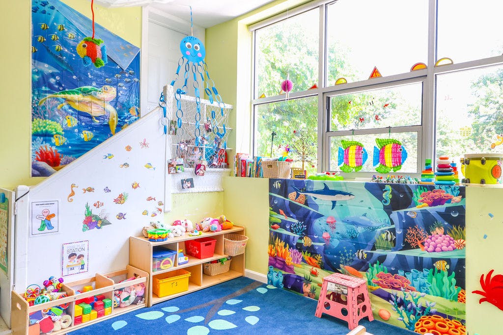 Playroom with ocean-themed decorations, toys, and large windows