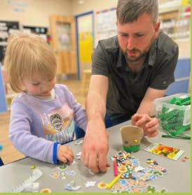 Adult and child doing crafts at a table