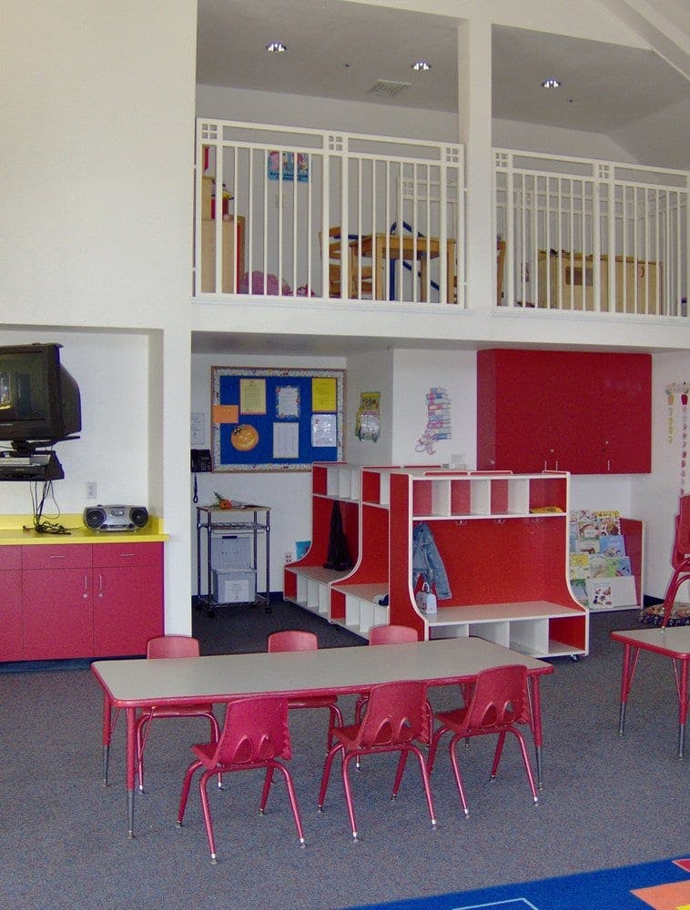 Classroom with tables, chairs, and a loft area