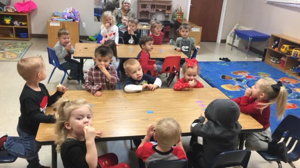 Children sitting at tables in a classroom