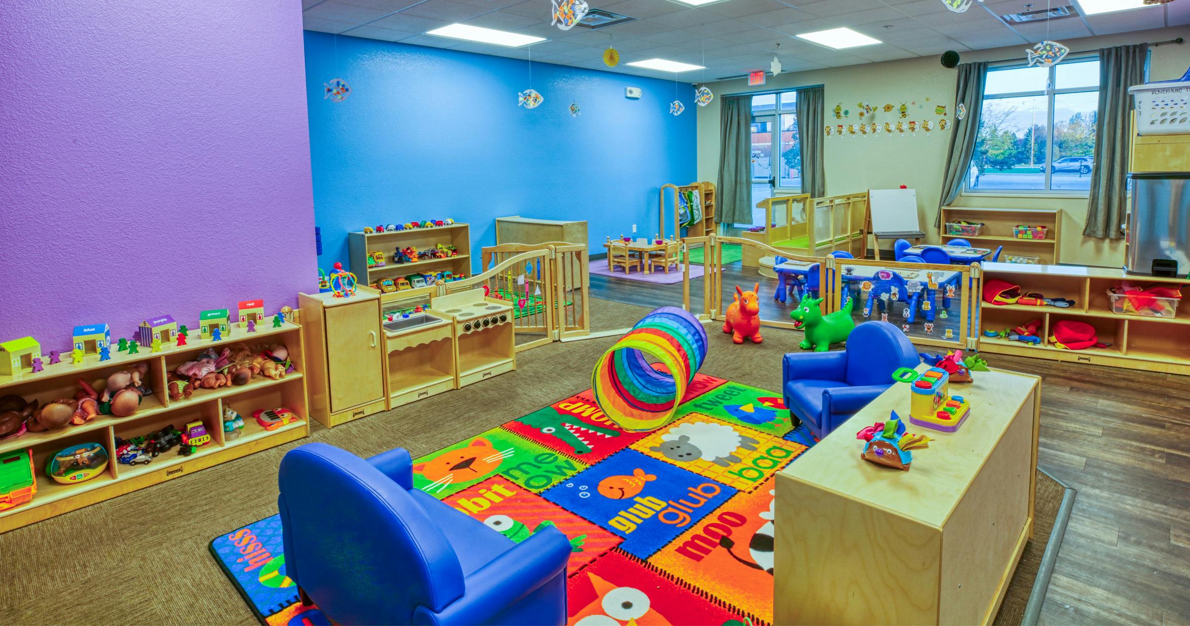 Colorful playroom with a play rug, toy kitchen, and small furniture