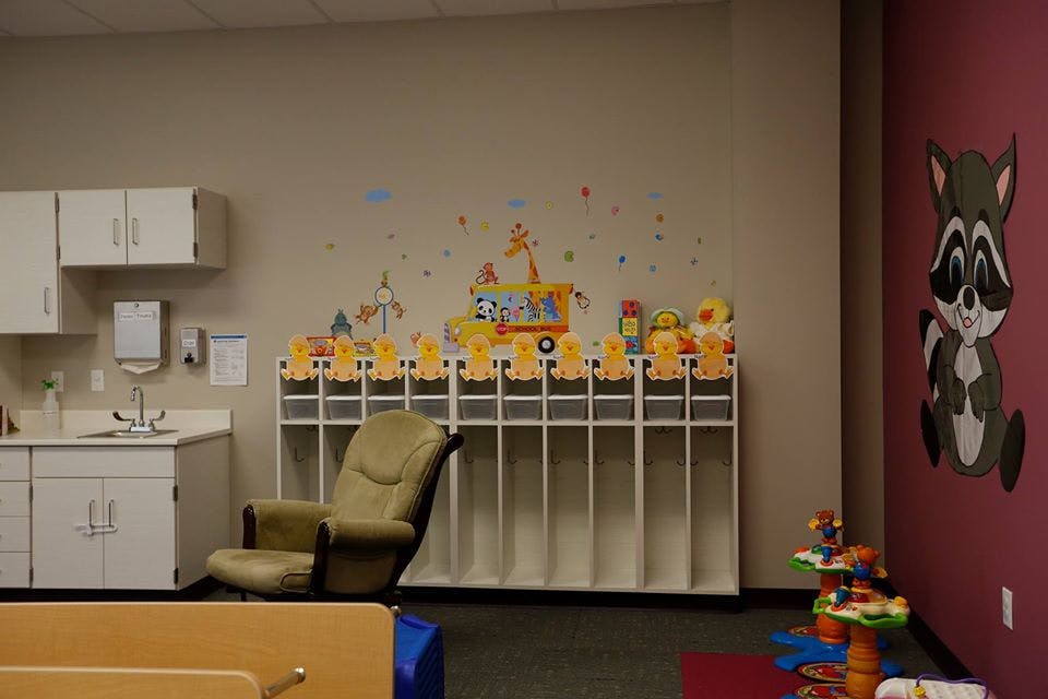 Classroom with cubbies, sink, chair, and wall decorations