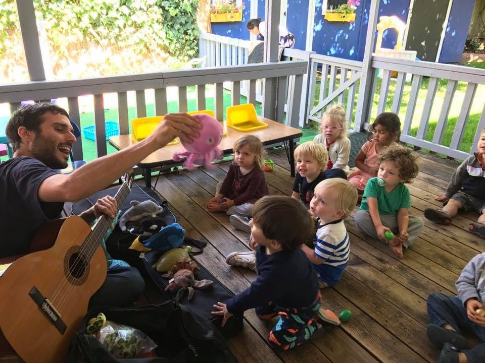 Person playing guitar for a group of children