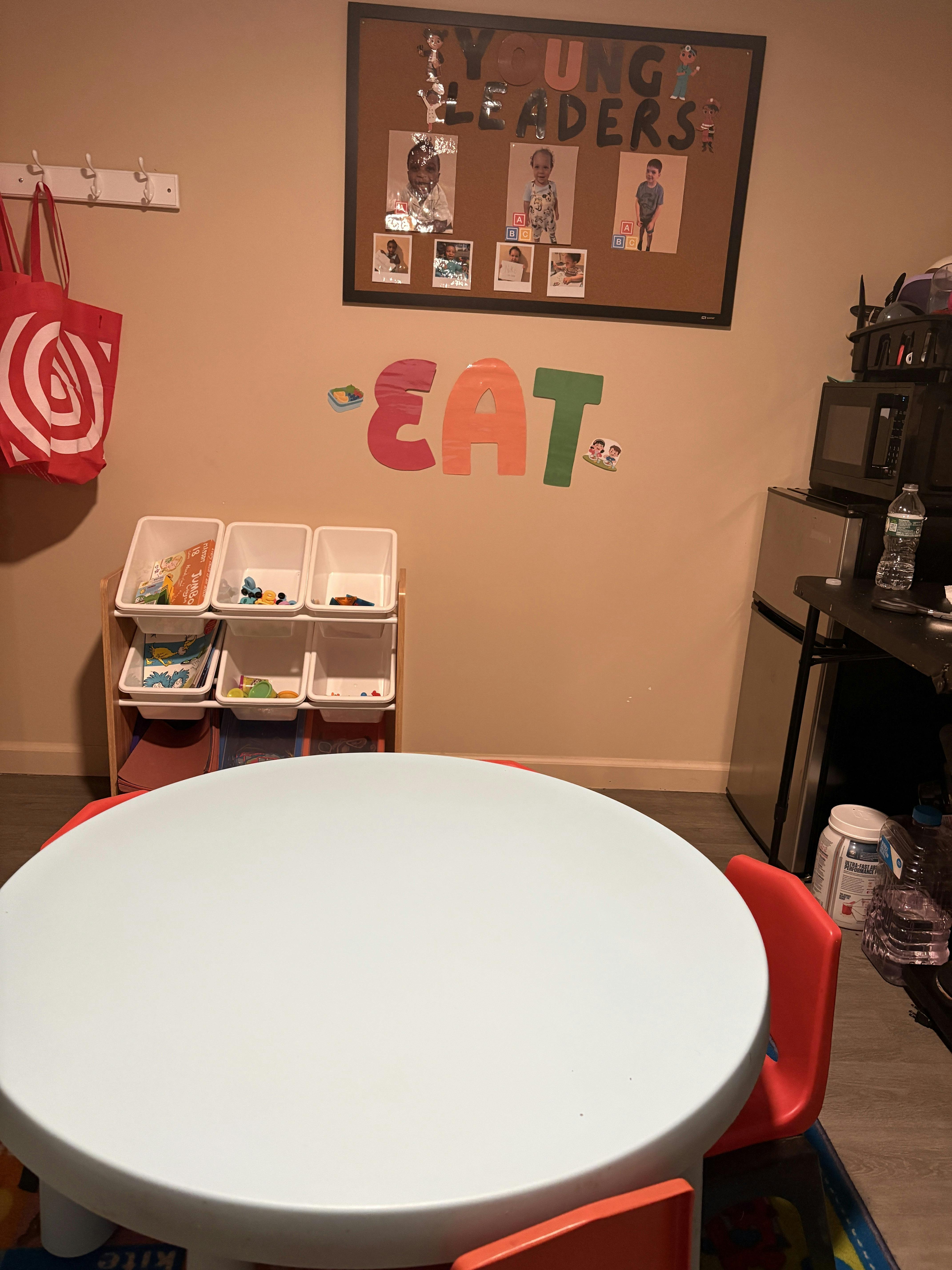 Round table with red chairs in a playroom or classroom setting