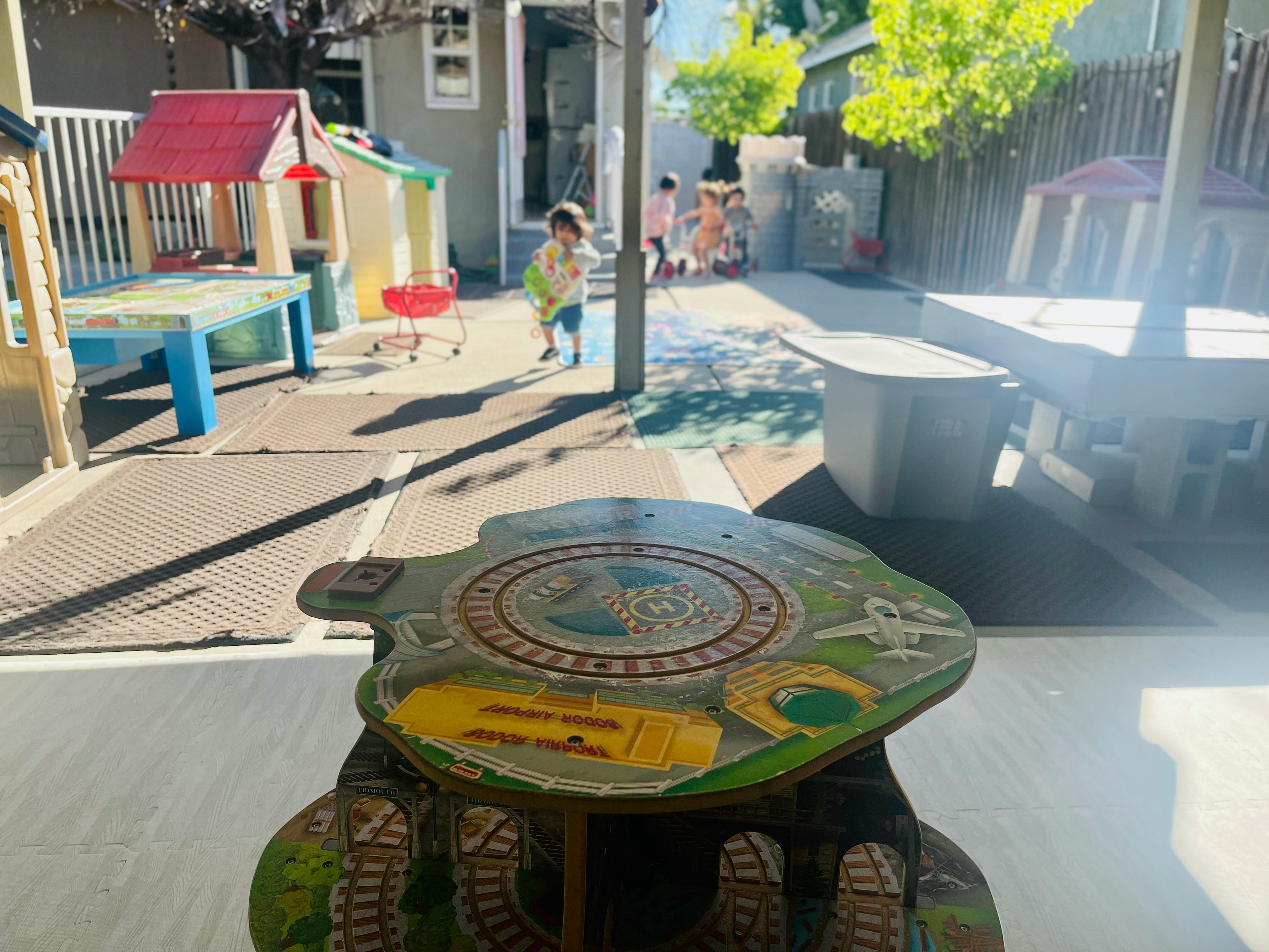 Child walking in a play area with a small table in the foreground