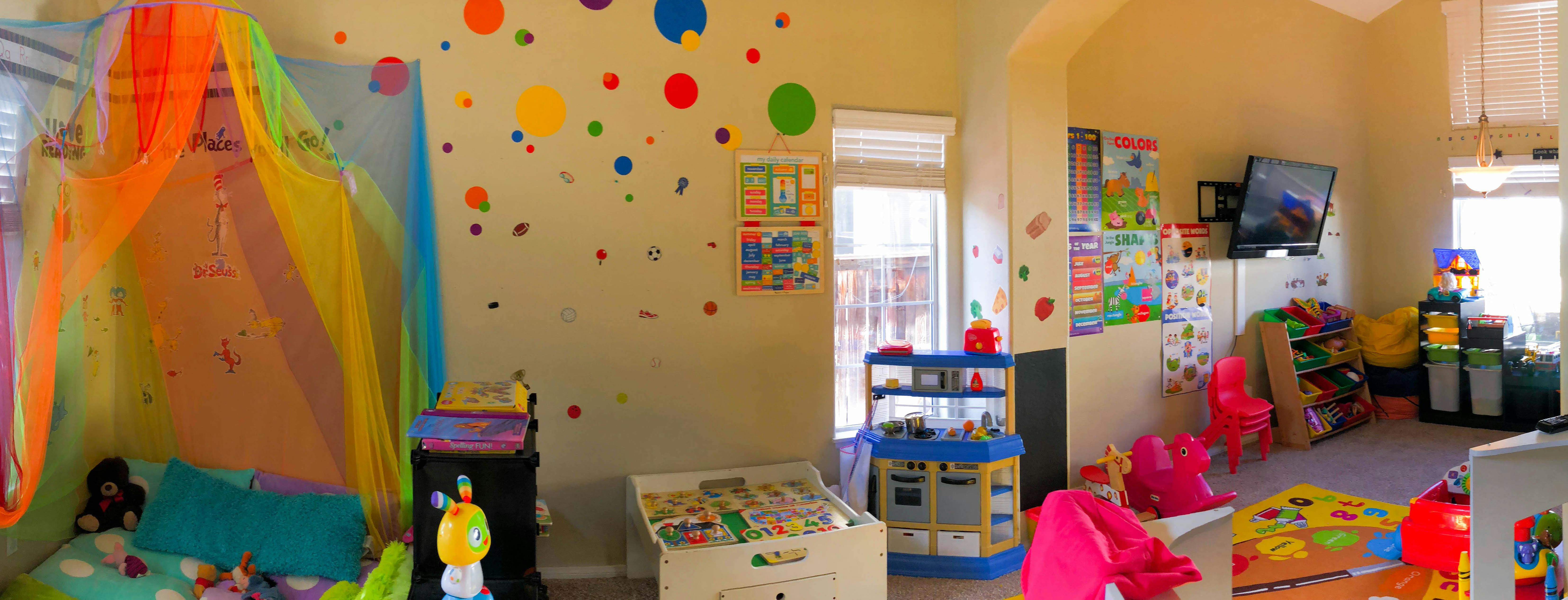 Playroom with colorful decorations, toys, and a rainbow canopy