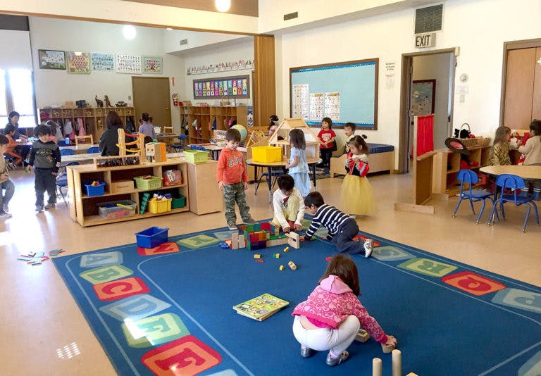 Children playing with blocks and toys in a classroom