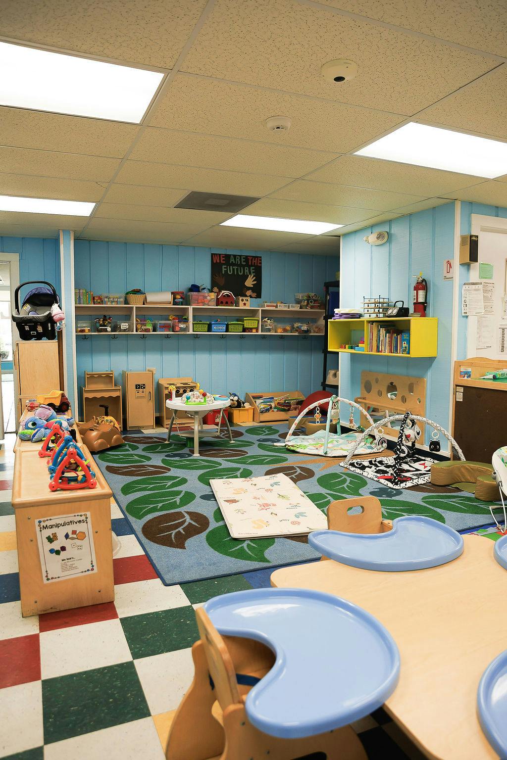 Childcare room with toys, play mats, and learning furniture