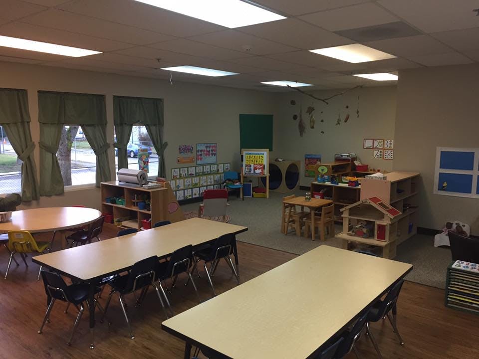Empty classroom with tables, chairs, and play areas