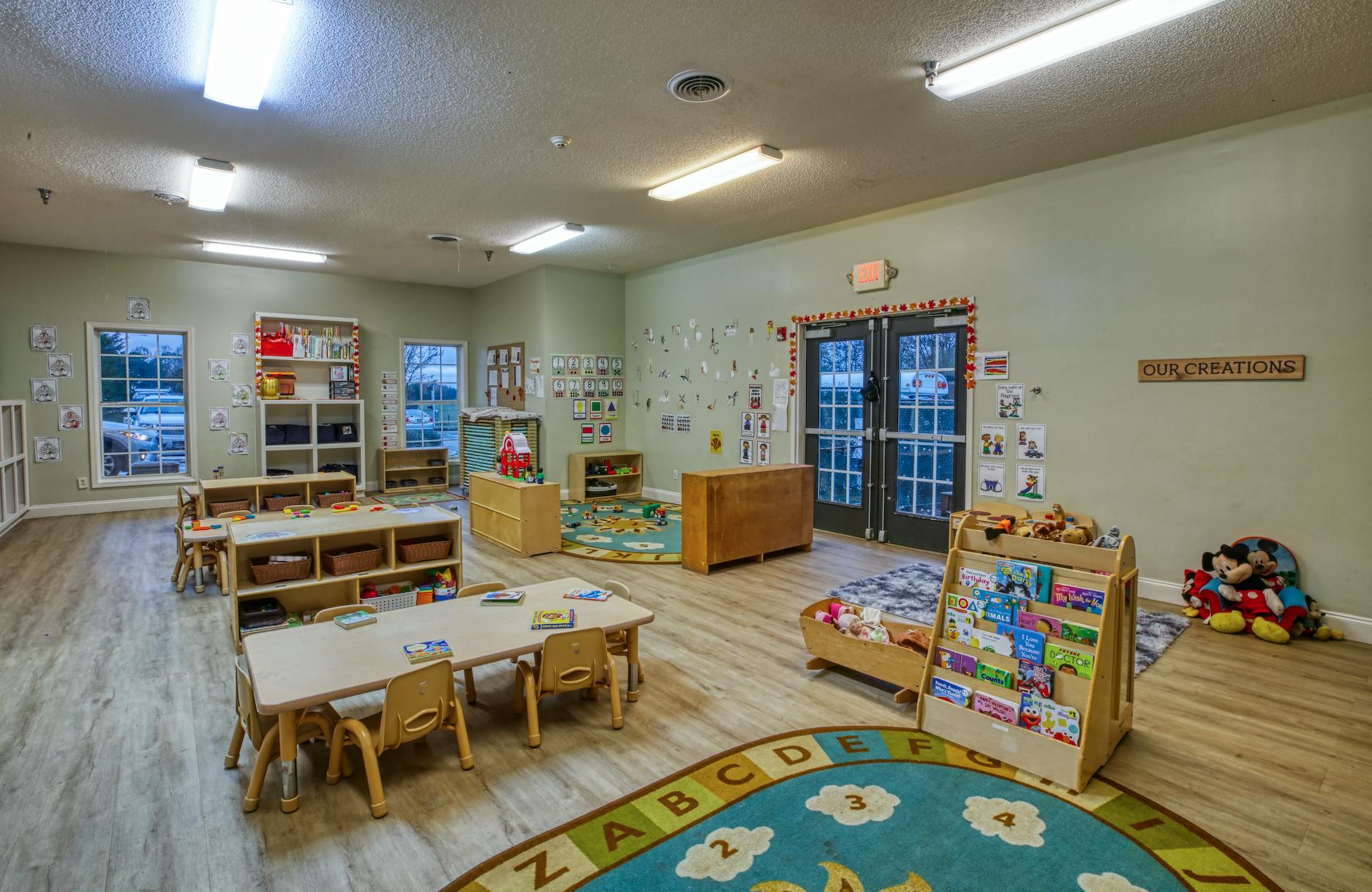 Classroom with small tables, chairs, and play areas