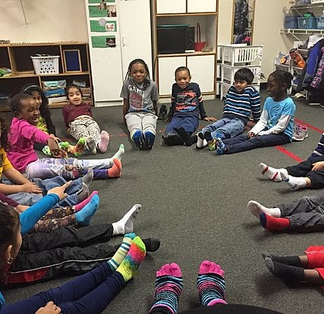 Children sitting in a circle on the floor in a classroom