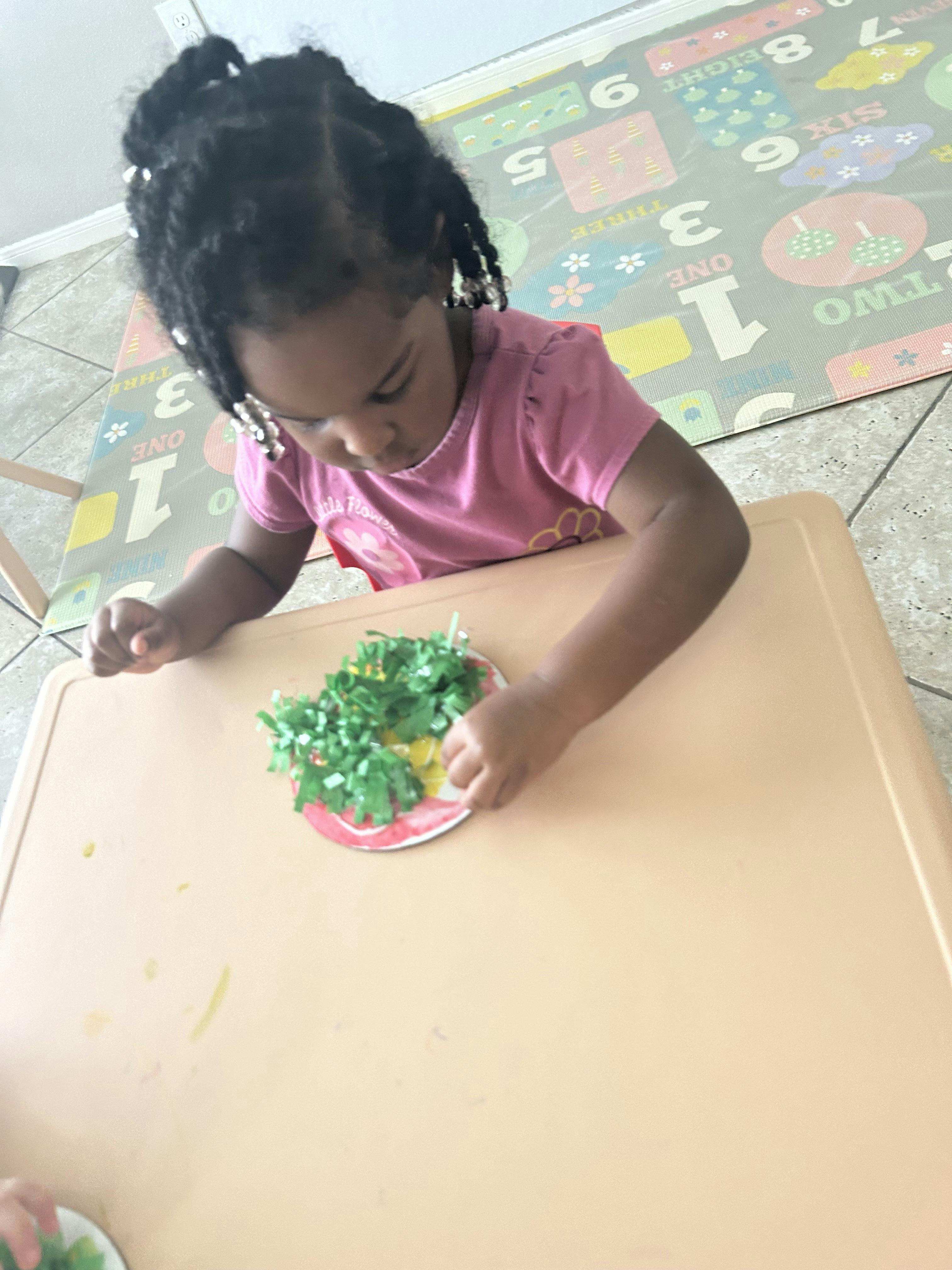 Child sitting at a table engaged in a craft project