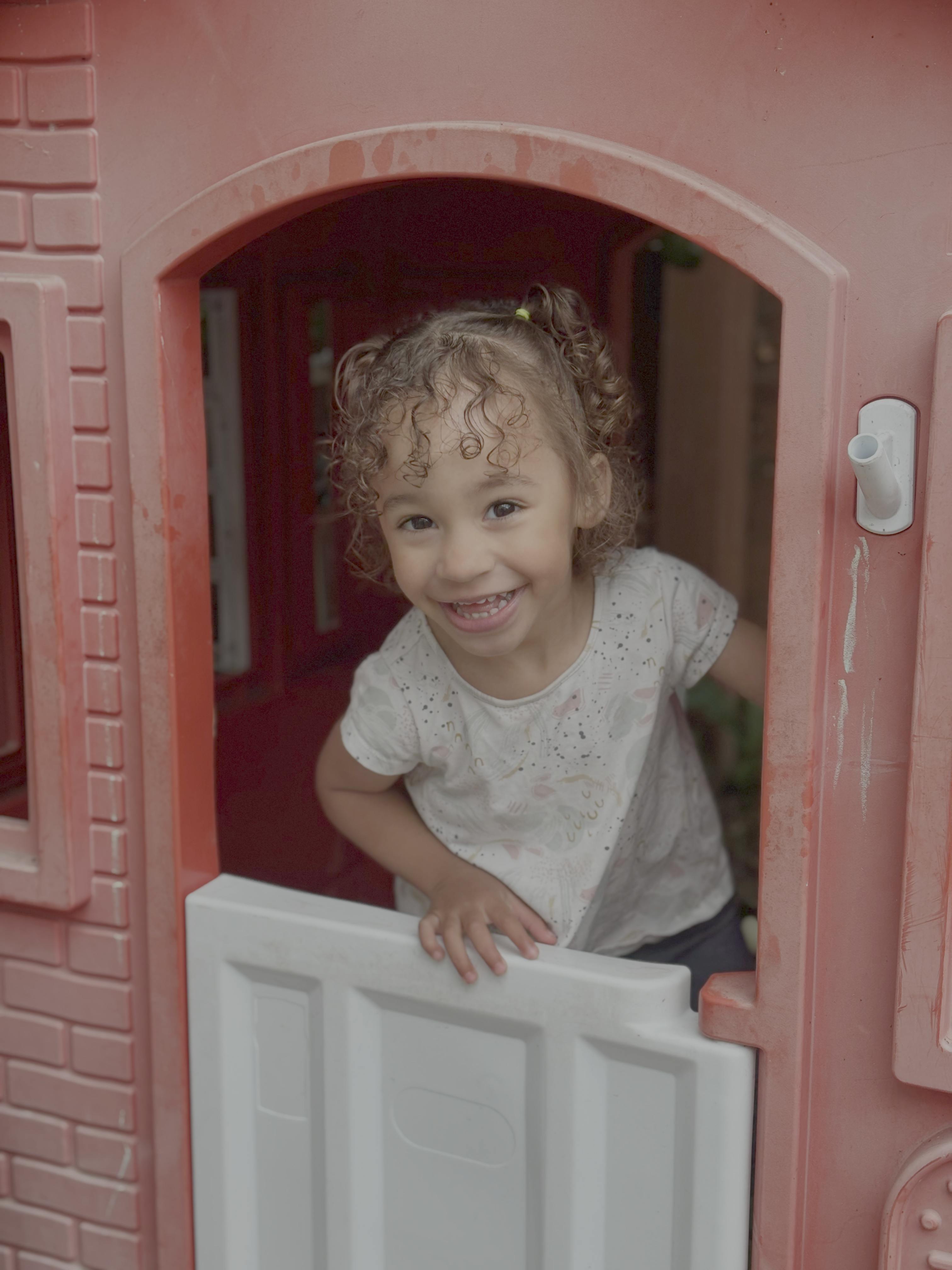Child looking out of a playhouse window