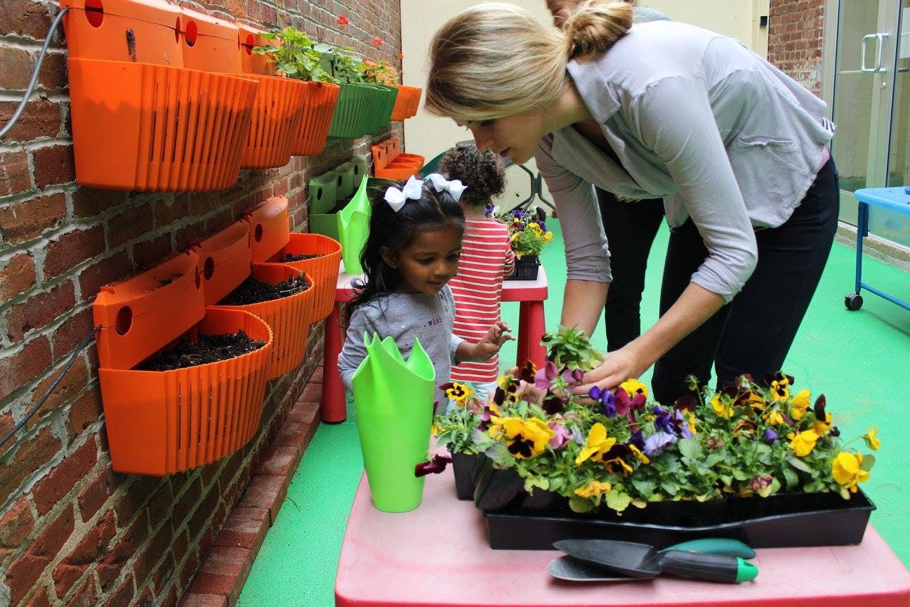 Adult and child planting flowers in a garden