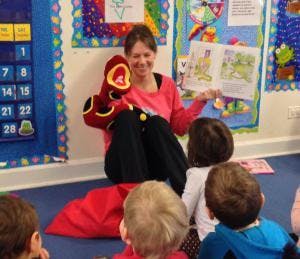 Adult reading a book to children in a classroom