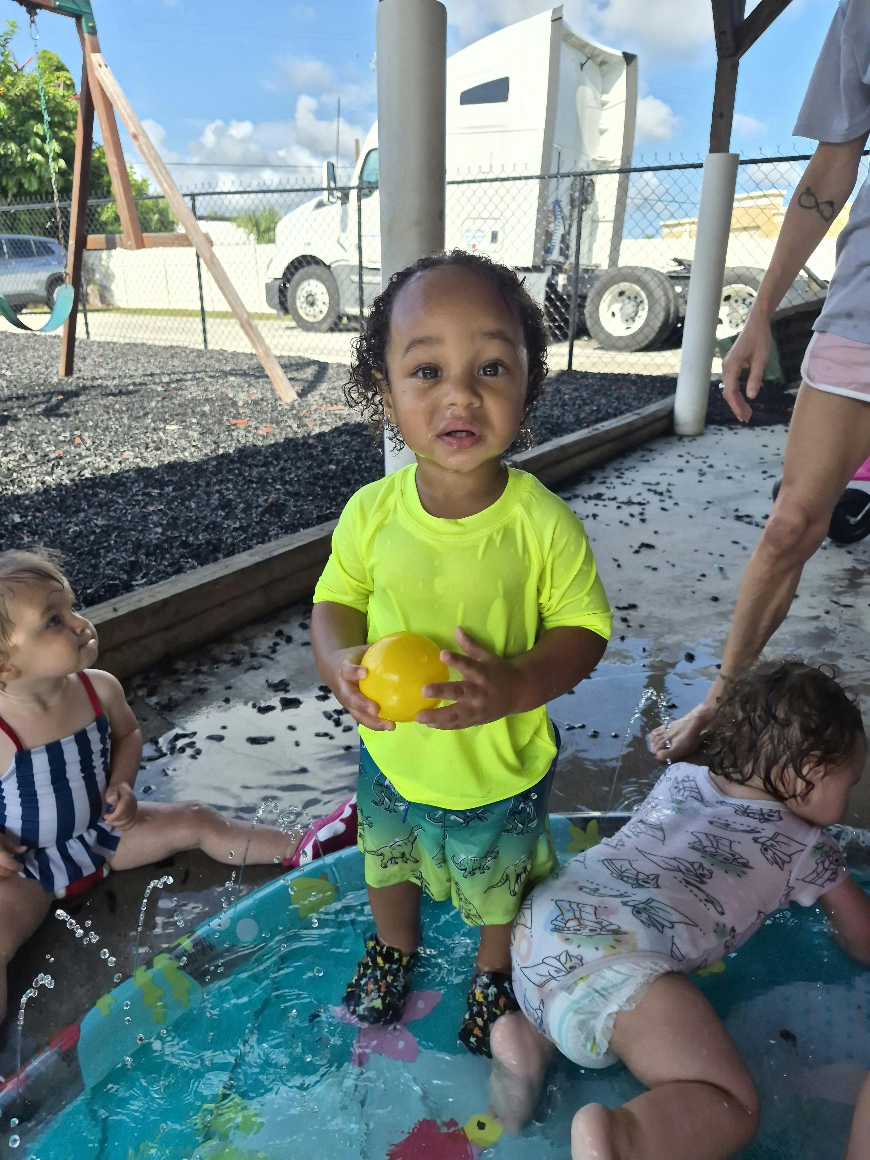 Children playing in a small outdoor inflatable pool