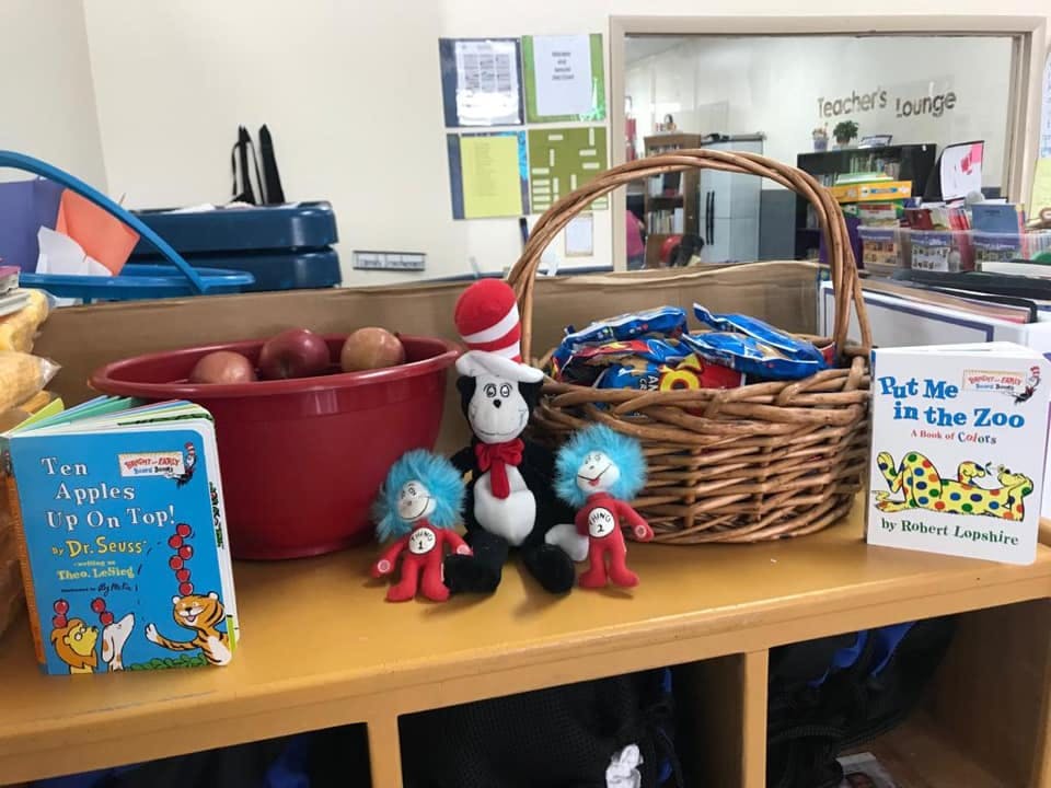 Dr Seuss books, plush toys, and a basket of items on a shelf