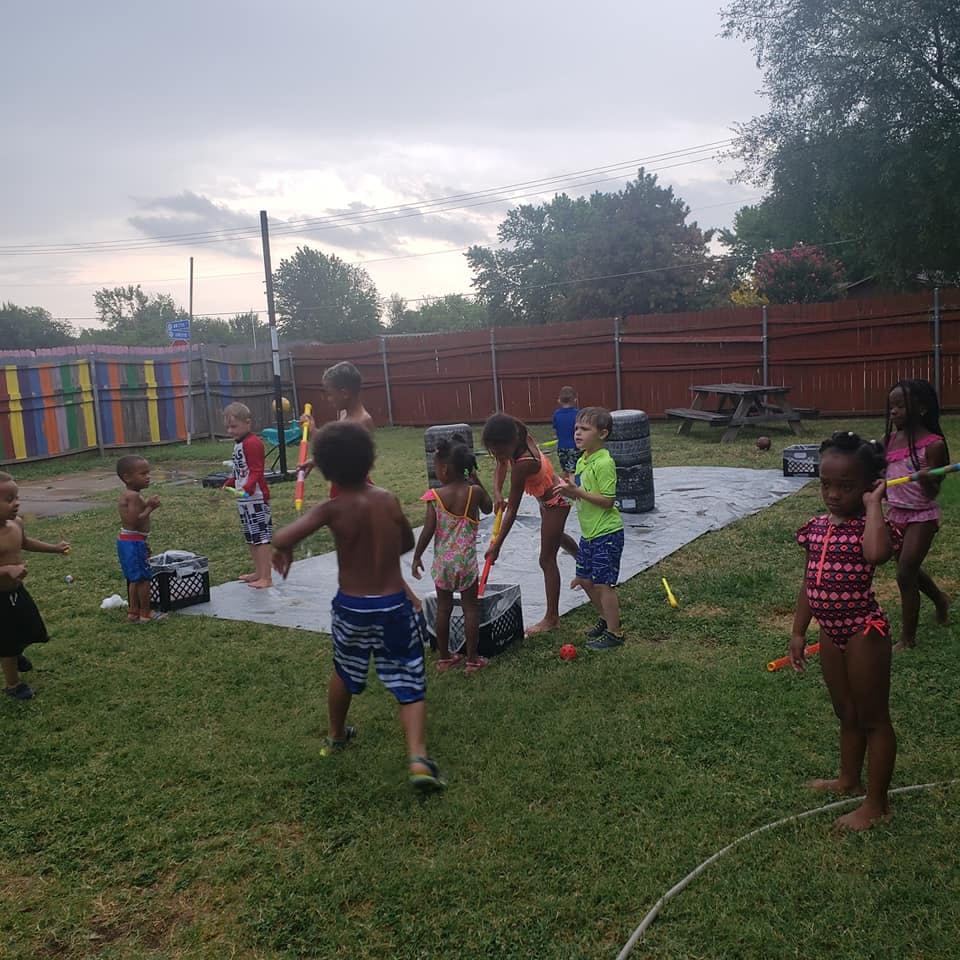 Children playing with water on a grassy area