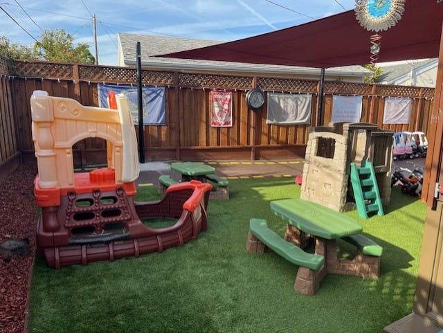 Outdoor play area with a toy pirate ship and picnic table
