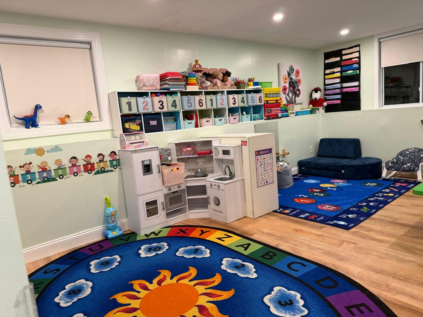 Playroom with children toy kitchen and educational rugs