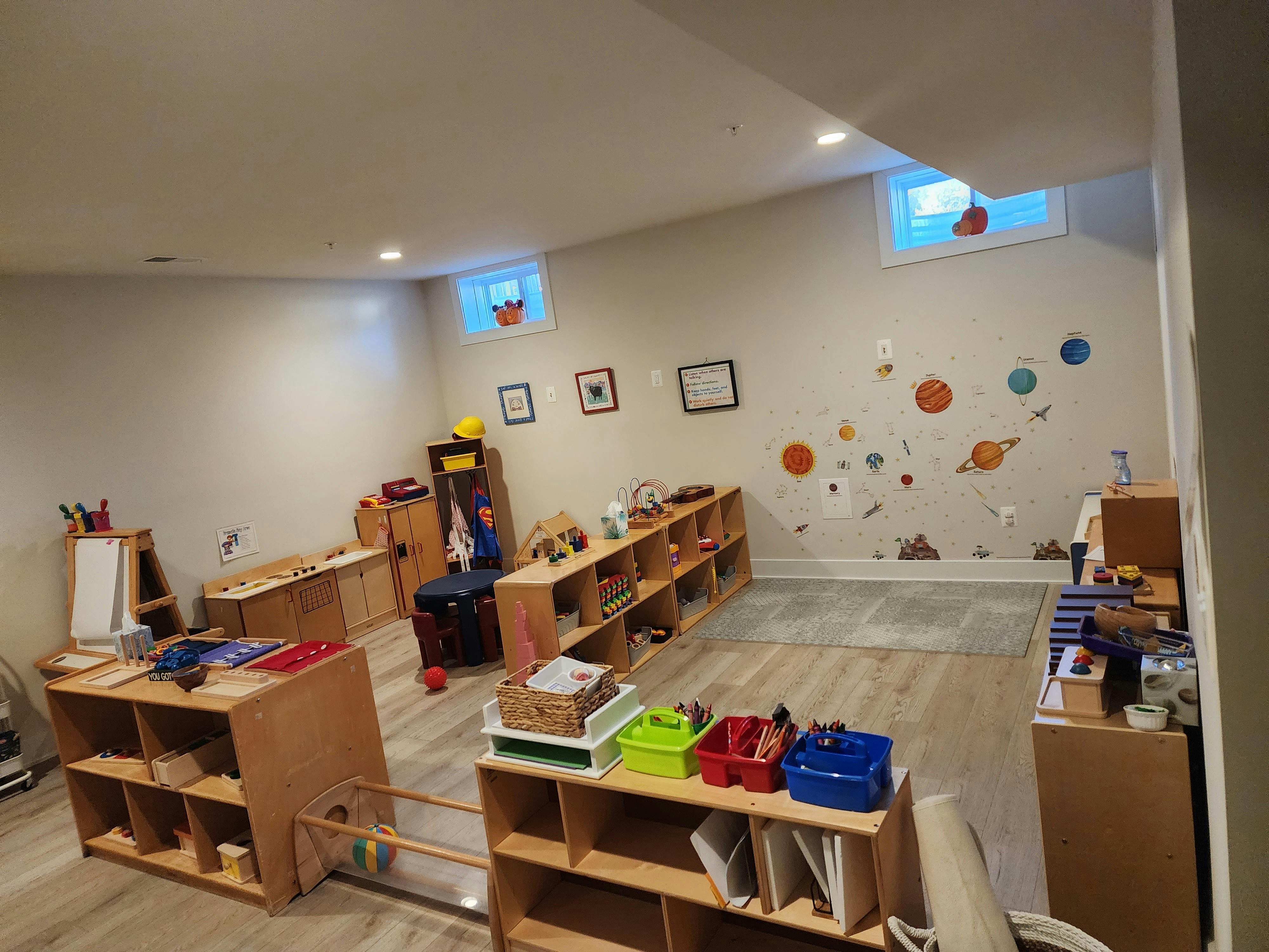 Classroom with shelves of learning materials and planet wall decals